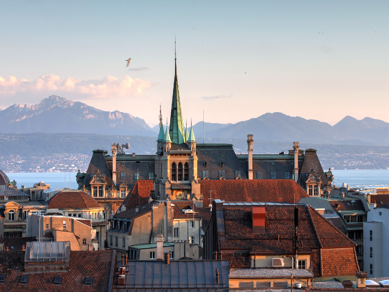 Agence SEO Lausanne - Vue sur les toits de Lausanne avec la cathédrale en arrière-plan et les montagnes en fond.