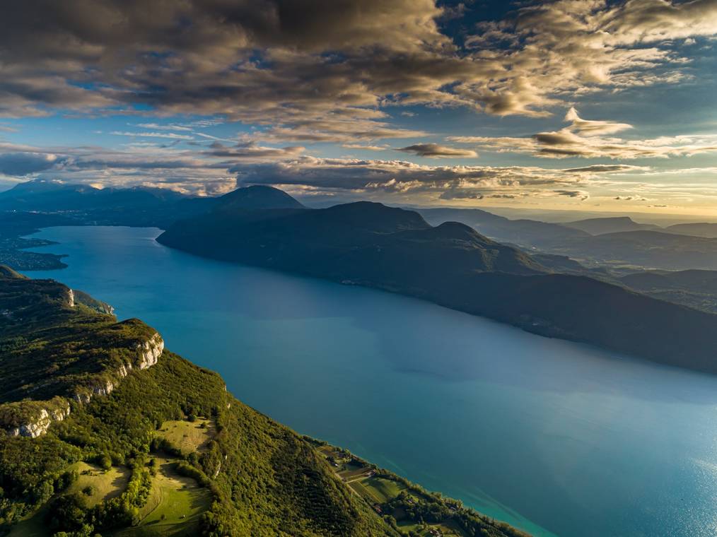 Consultant SEO Aix-les-Bains - Vue aérienne du lac du Bourget entouré de montagnes au coucher du soleil, près d'Aix-les-Bains.